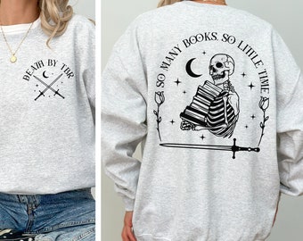 May include: Gray sweatshirt with a skeleton holding a stack of books and the text "So many books, so little time". The front of the sweatshirt has the text "Death by TBR" with a crescent moon and crossed swords.