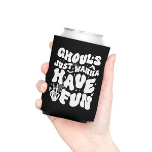 May include: Black and white can cooler with the text "Ghouls Just Wanna Have Fun" in a retro font. The design includes bats, stars, and a skeleton hand with a peace sign.