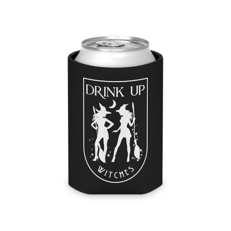 Puede incluir: Un enfriador de latas negro con un gr&aacute;fico blanco de dos brujas, una luna creciente y estrellas. El texto "DRINK UP WITCHES" se muestra en blanco, en arco. Dise&ntilde;ado para una lata de bebida est&aacute;ndar.