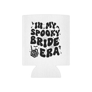May include: White can cooler with a black graphic that says "In My Spooky Bride Era" with a skeleton hand giving the middle finger.
