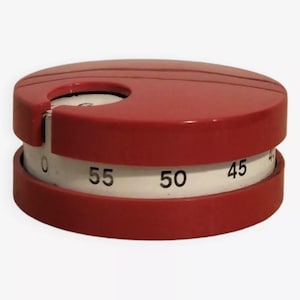 Peut inclure: Un minuteur de cuisine rouge avec un cadran blanc qui affiche les nombres de 0 à 60. Le minuteur est rond et a un petit trou en haut.