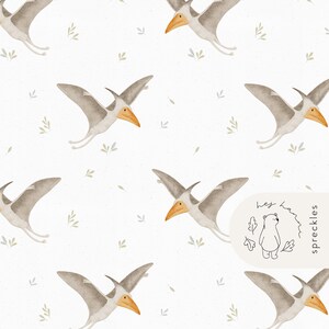 May include: Watercolor pattern featuring flying pterodactyls in shades of gray with orange beaks, set against a white background with small green leaf accents. The design includes a logo with a bear and the text "hey han spreckles".