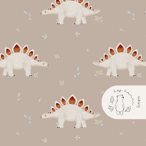 May include: A repeating pattern featuring watercolor illustrations of beige Stegosaurus dinosaurs with brown and orange plates on a taupe background. Small green and blue leaf accents are scattered throughout the design. The image includes a logo with a bear and the text "linen".