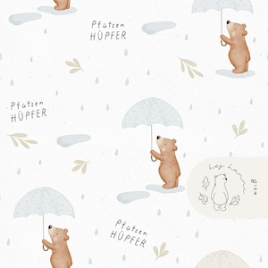 May include: A whimsical pattern featuring cartoon bears holding light blue umbrellas in the rain. The bears are light brown, and the background is white with raindrops, puddles, and leaf accents. Text includes "Pfützen HÜPFER".
