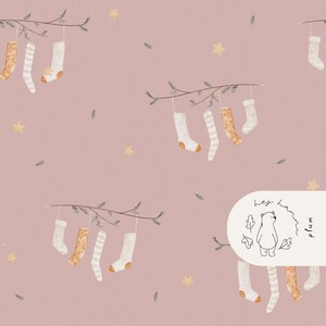 May include: A repeating pattern featuring Christmas stockings in white, beige, and gold, with stars and sprigs on a dusty rose backdrop. The stockings hang from branches, creating a festive, whimsical design. The image includes the text "hey ham plum".
