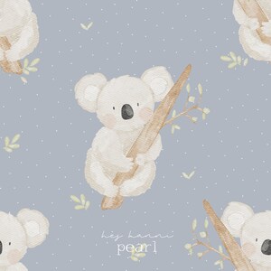Könnte beinhalten: Aquarell-Illustration mit einem sich wiederholenden Muster von Koalas, die Äste halten, vor einem hellblauen Hintergrund mit weißen Punkten. Die Koalas sind in Weiß- und Beigetönen gehalten, mit kleinen grünen Blättern. Der Text "hey hanni pearl" befindet sich unten.