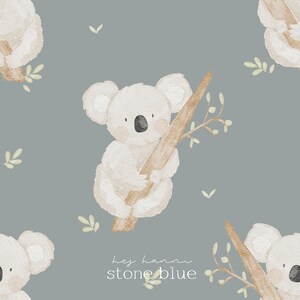 Könnte beinhalten: Aquarell-Illustration mit einem Muster von Koalas, die Baumzweige auf einem steingrauen Hintergrund halten. Der Text "hey hanni stone blue" befindet sich unten. Die Koalas sind hellbeige mit schwarzen Nasen und rosigen Wangen.