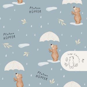 Puede incluir: Patrón repetitivo sobre fondo azul claro con osos marrones sosteniendo paraguas blancos, con gotas de lluvia, nubes y hojas. También está presente el texto "Pfützen HÜPFER".