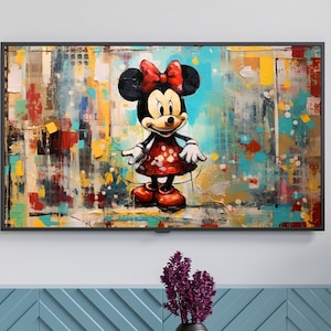 Puede incluir: Una pintura abstracta colorida de Mickey Mouse con un vestido rojo con lunares blancos y un lazo rojo. La pintura está enmarcada en negro y colgada en una pared blanca sobre un armario azul.