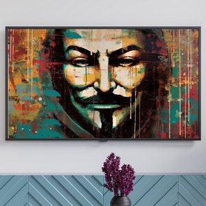 May include: A colorful abstract painting of a person wearing a mask. The painting is framed and hanging on a white wall above a blue cabinet with a clock and a vase of purple flowers on a wooden table.