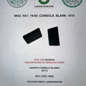 May include: Two black center console blanks for a Mazda RX7, 1979-1985. The blanks are labeled "FITS/FOR MAZDAS DISCONTINUED BY MANUFACTURER" and "FACTORY PART# UNOBTAINIUM".