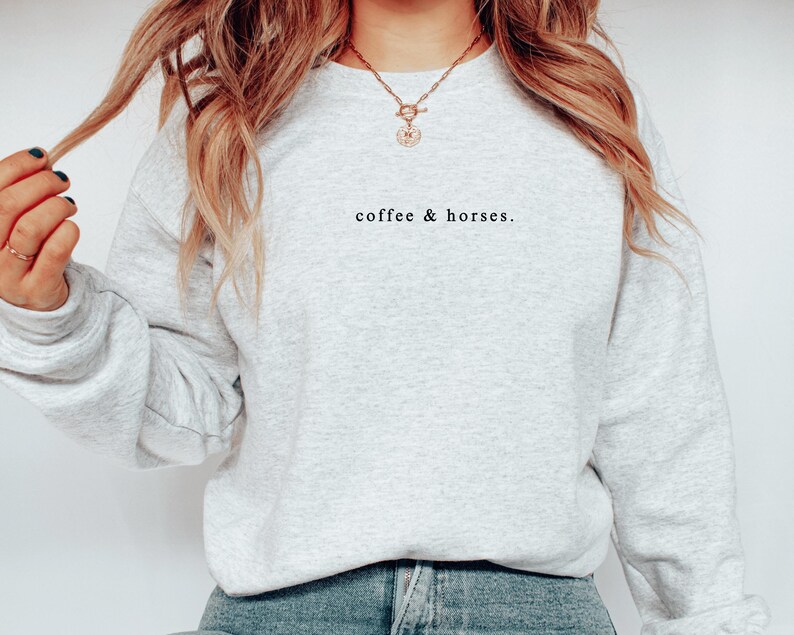 K&ouml;nnte beinhalten: Ein hellgraues Sweatshirt mit dem Text "coffee & horses." in Schwarz. Das lang&auml;rmlige Oberteil mit Rundhalsausschnitt ist aus einem weichen Material gefertigt. Das Sweatshirt hat einen l&auml;ssigen Stil.