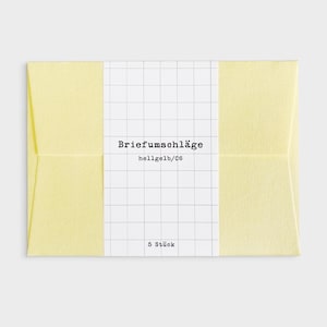 Könnte beinhalten: Ein Paket mit fünf hellgelben Umschlägen. Die Umschläge sind mit einem weißen Band mit dem Text "Briefumschläge" und "hellgelb/C6" umwickelt. Das Band ist mit einem Rastermuster und dem Text "5 Stück" bedruckt.