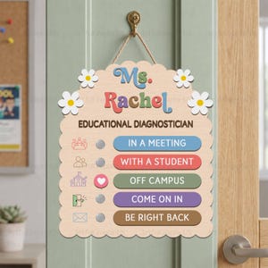 May include: A light wood scalloped door sign featuring the text Ms. Rachel Educational Diagnostician with white flower accents. It includes five status options with circular sliders: In a Meeting, With a Student, Off Campus, Come On In, and Be Right Back.