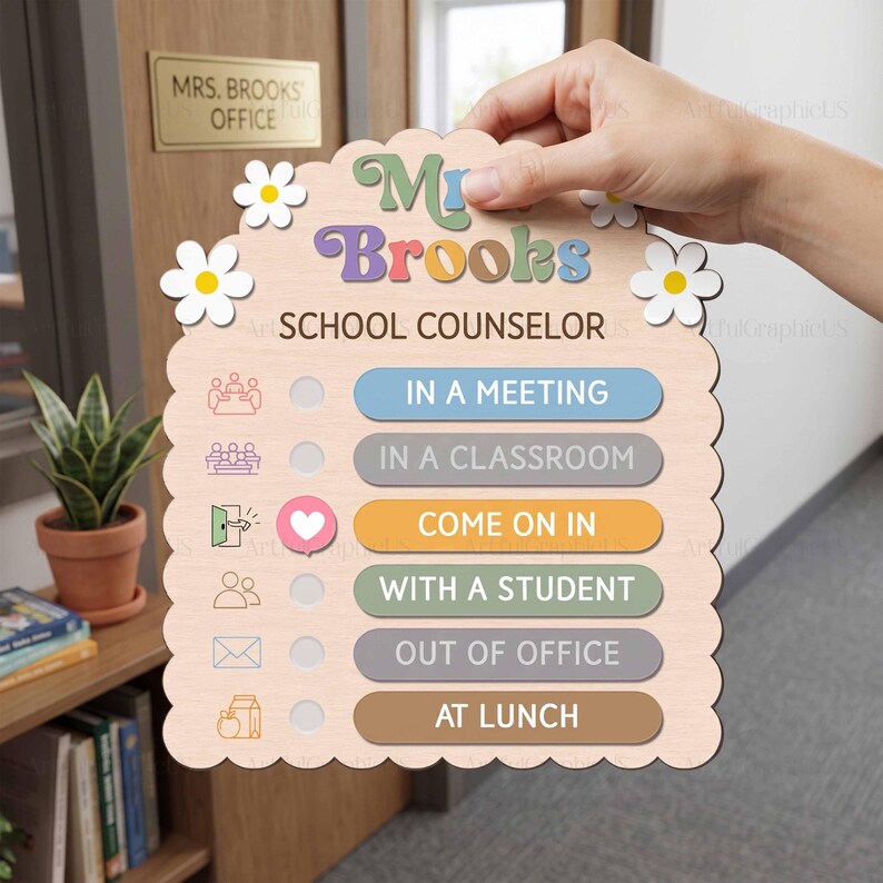 May include: A scalloped wooden sign featuring the text "Mrs. Brooks SCHOOL COUNSELOR" with white daisy accents. It includes a status tracker with options: IN A MEETING, IN A CLASSROOM, COME ON IN, WITH A STUDENT, OUT OF OFFICE, and AT LUNCH.