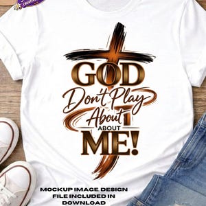 May include: White t-shirt with a cross graphic and the text "GOD Don't Play About ME!". The design features brown and black accents. The shirt also includes the text "MOCKUP IMAGE. DESIGN FILE INCLUDED IN DOWNLOAD".