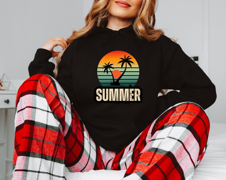 Puede incluir: Sudadera negra con un gr&aacute;fico de puesta de sol retro con palmeras y la palabra "SUMMER" en una fuente vintage.