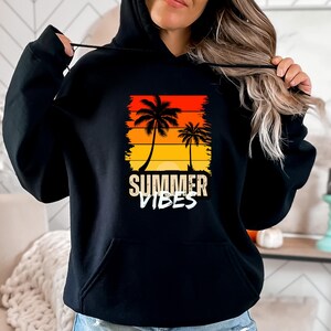 May include: Black hoodie with a graphic of palm trees and a sunset. The text "Summer Vibes" is printed below the graphic.