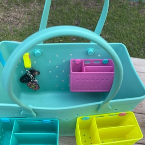 May include: A light blue tote bag with a handle, featuring a perforated design. Includes a pink and two other coloured organiser inserts. A set of keys with a flower charm hangs from the handle.