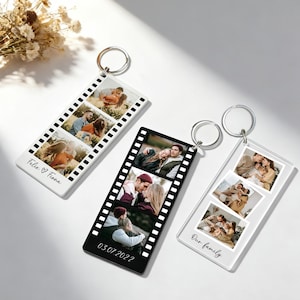 Puede incluir: Tres llaveros personalizados con fotos, cada uno con un diseño de tira de película. Uno es blanco con "Felix & Fiona", otro es negro con "03.07.2022", y el tercero es transparente con "Our family". Cada llavero tiene un llavero plateado.