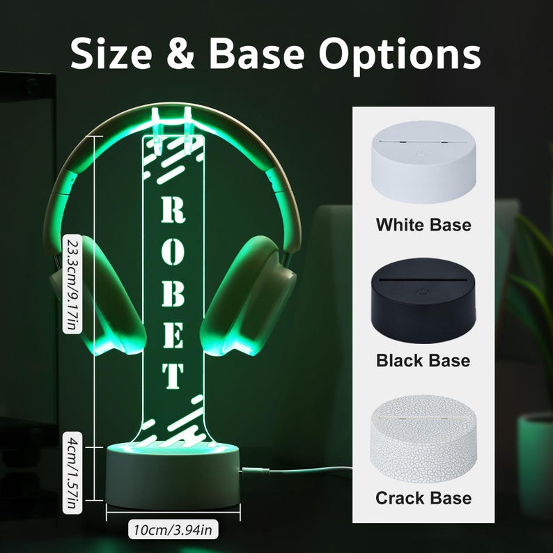 Puede incluir: L&aacute;mpara con forma de auriculares LED verdes con el nombre "ROBERT" iluminado en blanco. La l&aacute;mpara mide 23,3 cm de alto y 10 cm de ancho, con una base de 4 cm de alto. La imagen muestra opciones de base blanca, negra o agrietada.