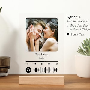 Puede incluir: Una placa acr&iacute;lica blanca con una foto de una pareja, un icono de reproductor de m&uacute;sica y el t&iacute;tulo de la canci&oacute;n "Too Sweet" de Hozier. La placa tiene un soporte de madera y texto negro que dice "Opci&oacute;n A Placa acr&iacute;lica + Soporte de madera (sin luz LED) Texto negro".