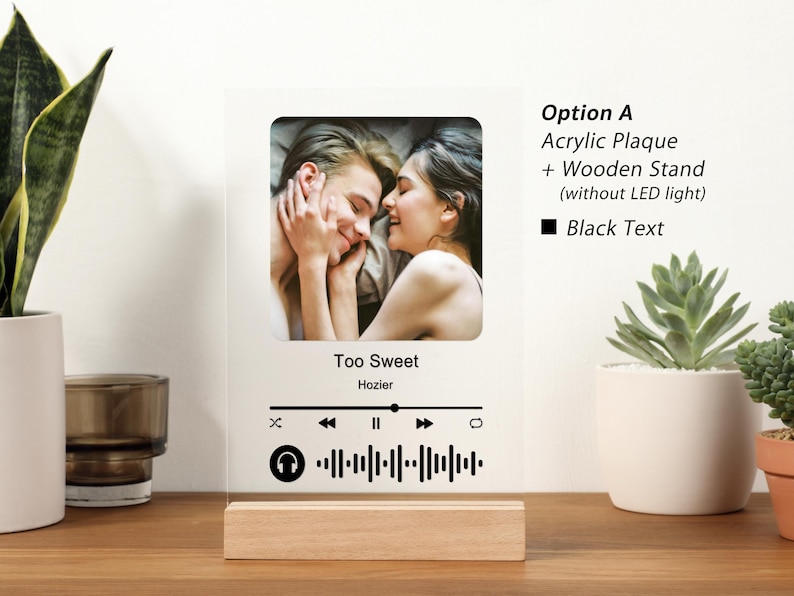 Puede incluir: Una placa acr&iacute;lica blanca con una foto de una pareja, un icono de reproductor de m&uacute;sica y el t&iacute;tulo de la canci&oacute;n "Too Sweet" de Hozier. La placa tiene un soporte de madera y texto negro que dice "Opci&oacute;n A Placa acr&iacute;lica + Soporte de madera (sin luz LED) Texto negro".