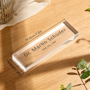 May include: A clear acrylic desk nameplate, 7.8 inches long and 2.28 inches wide, with the name "Dr. Martin Sch&uuml;der" printed in black. The nameplate also includes the credentials "DNP, RN, CNM".