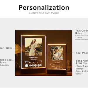 Puede incluir: Dos placas de fotos personalizadas con un nombre de canci&oacute;n y artista, una foto y un gr&aacute;fico de onda musical. Las placas est&aacute;n en un soporte de madera con luz. Las opciones de color del texto son negro o blanco.