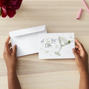 May include: A white card with a green martini glass with an olive on a stick and the text "A Tiny Bit Older".
