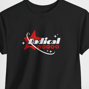 May include: Black t-shirt featuring a red star graphic with the word "Radical" in white script. Below the word, the word "LEFTOY" is spelled out in red circles. The design is surrounded by white curved lines and small star accents.
