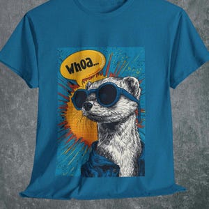 Puede incluir: Camiseta de color turquesa con un gráfico de un hurón con gafas de sol y una chaqueta azul, con un bocadillo que dice "Whoa...". El fondo incluye una explosión naranja y roja. El diseño está impreso en la parte delantera.