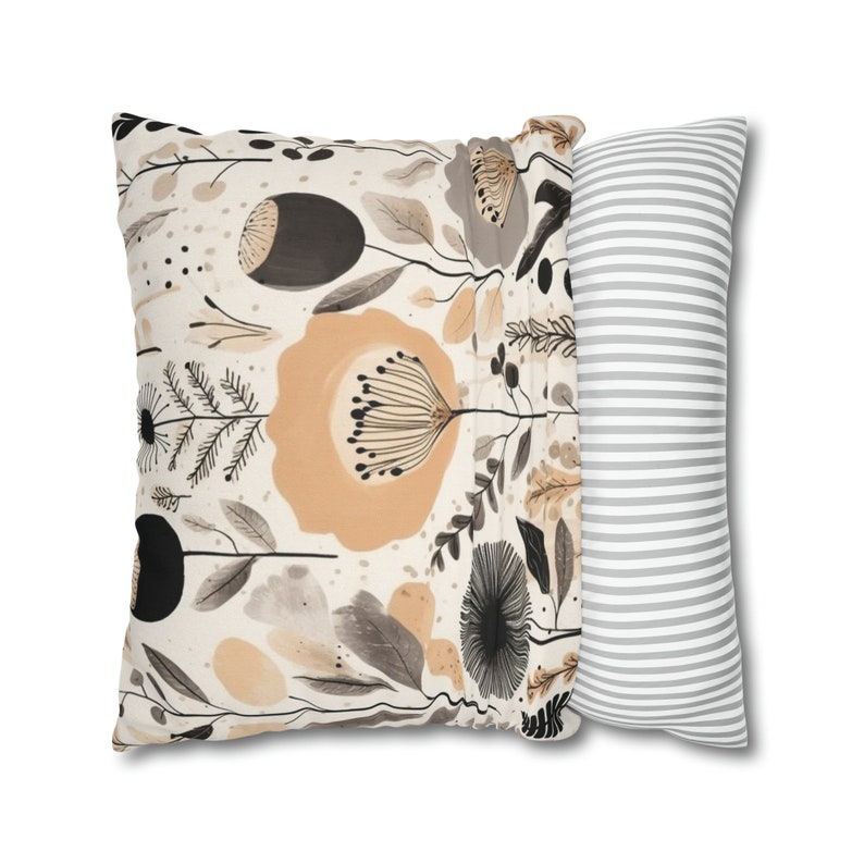 May include: Two decorative throw pillows. One pillow has a floral pattern with beige, brown, and black colors. The other pillow has a gray and white striped pattern.