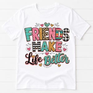 Może przedstawiać: Biały t-shirt z krótkim rękawem z kolorowym nadrukiem graficznym o treści FRIENDS MAKE Life Better. Litery ozdobione są różnymi wzorami, w tym turkusowym usłojeniem drewna, różowymi kropkami, wzorem w panterkę, złotym brokatem i czarną kratą.