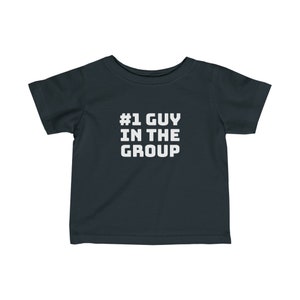 May include: Dark gray toddler t-shirt with the text "#1 GUY IN THE GROUP" in white block letters. The shirt has short sleeves and a crew neck.