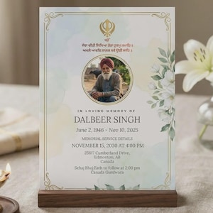 Pode incluir: Um cartão de memória com uma foto de Dalbeer Singh, 2 de junho de 1946 - 10 de novembro de 2025. O cartão é exibido em um suporte de madeira. Um pequeno castiçal de latão e um vaso de lírios brancos também estão na mesa.
