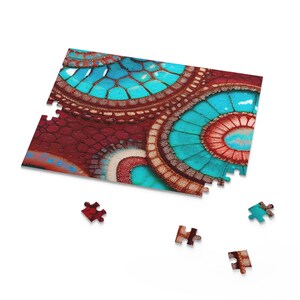 Pode incluir: Um quebra-cabeça parcialmente montado com um design abstrato vibrante. O quebra-cabeça apresenta círculos concêntricos em tons de azul-turquesa, vermelho e marrom. Várias peças do quebra-cabeça estão espalhadas ao redor do quebra-cabeça parcialmente concluído, em um fundo branco.