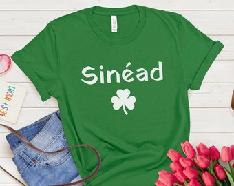 May include: Green t-shirt with white text that says "Sinéad" and a white shamrock.