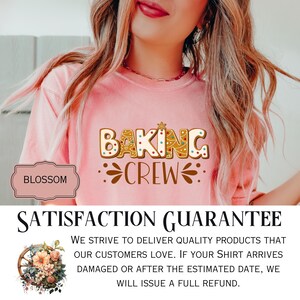 May include: A light pink short-sleeved t-shirt featuring a graphic design of gingerbread-style letters that spell out BAKING CREW. The letters are decorated with colorful dots and a small star. The text is brown and includes decorative flourishes.