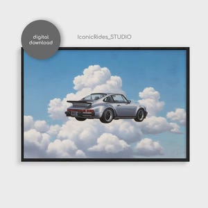 May include: A framed print featuring a silver sports car floating among fluffy white clouds against a blue sky. The artwork has a vintage aesthetic, with the words "digital download" in a gray circle in the upper left corner.