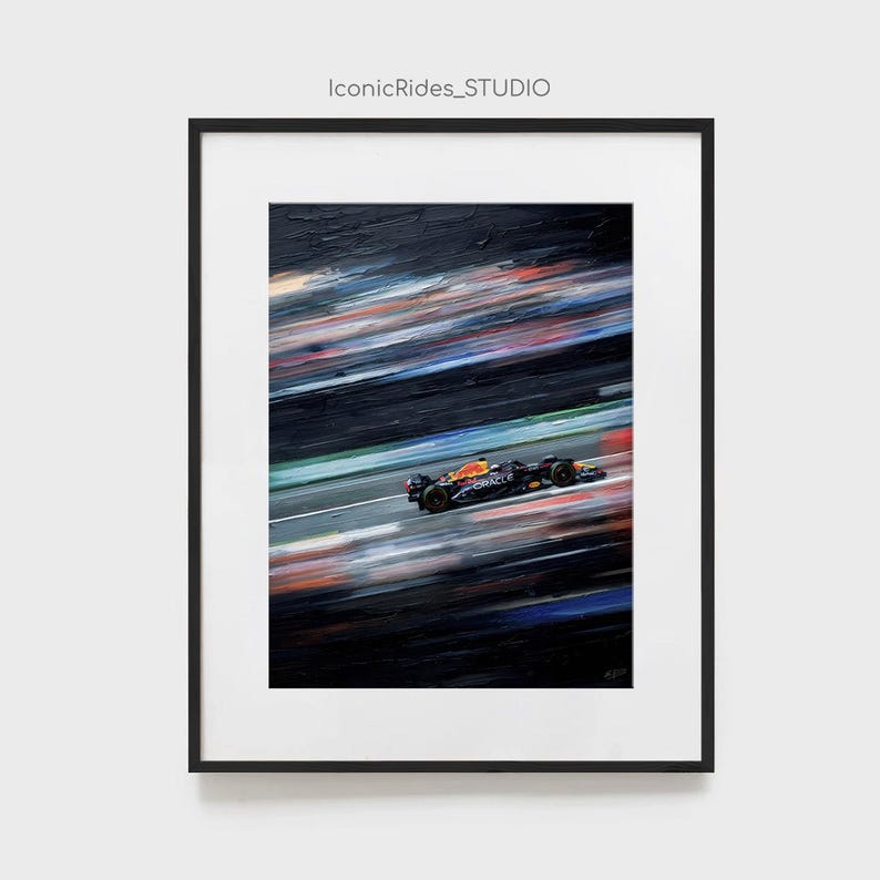 May include: Framed artwork of a Formula 1 race car speeding on a track. The car is black, orange, and blue, with the Oracle logo visible. The background features blurred streaks of color, suggesting speed. The text "IconicRides_STUDIO" is at the top.