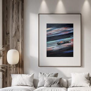 May include: Framed artwork depicting a Formula 1 race car in motion. The painting features a dark background with streaks of color, suggesting speed. The car is primarily black with red and yellow accents, racing on a green track.