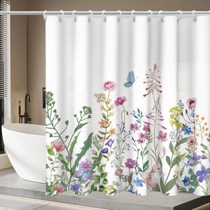 May include: White shower curtain featuring a watercolor floral design with pink, purple, yellow, and blue flowers, and a blue butterfly. The curtain has a rod with white rings.