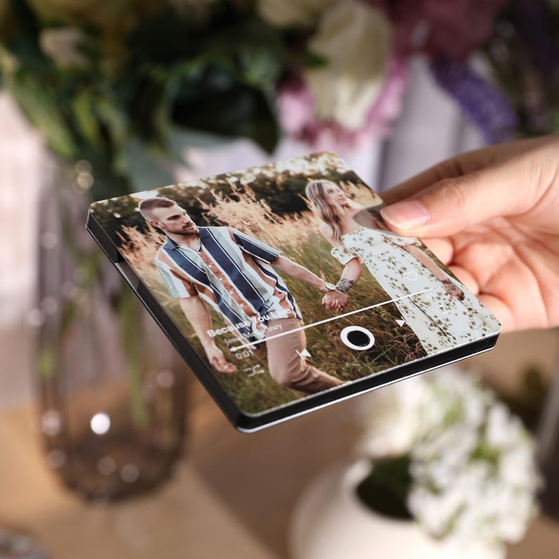 Pode incluir: Uma capa de telefone personalizada com uma foto de um casal de m&atilde;os dadas em um campo. A capa tem uma borda preta e um design de interface de reprodutor de m&uacute;sica. O texto "Because You" &eacute; vis&iacute;vel.