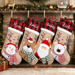 Könnte beinhalten: Vier Weihnachtsstrümpfe aus Jute mit rot-schwarz karierten Bündchen, personalisiert mit den Namen Mum, Amely, Daddy und Zach. Die Strümpfe zeigen gestickte Rentiergeweihe mit bunten Lichtern und Plüschfiguren: Schneemann, Rentier, Weihnachtsmann und Eisbär.