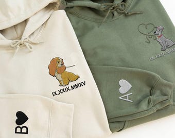 Puede incluir: Dos sudaderas con capucha de color crema y verde oliva con corazones bordados y un perro de dibujos animados. La sudadera de color crema tiene el texto "IX. XXIX. MMXV" y un perro de dibujos animados. La sudadera de color verde oliva tiene el texto "IX. XXIX. MMXV" y un perro de dibujos animados con un corazón.
