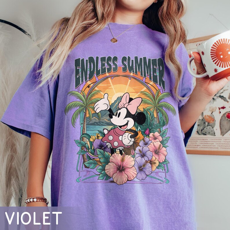 May include: Violet t-shirt featuring a graphic of Minnie Mouse in a tropical setting with the words "Endless Summer". The design includes palm trees, flowers, and a sunset. The shirt is a comfortable, casual style.