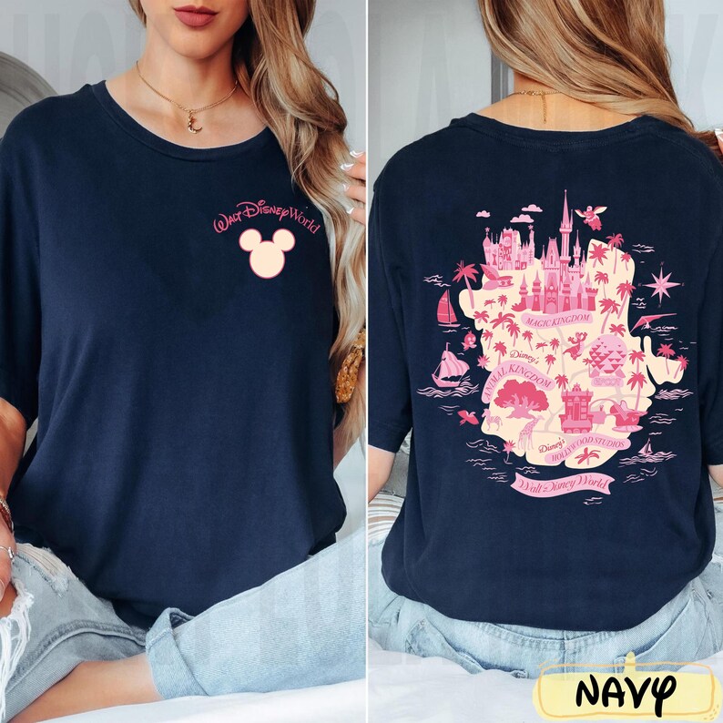 May include: Navy blue t-shirt featuring a pink Mickey Mouse head and "Walt Disney World" text on the front. The back displays a pink map of the park with various attractions. The word "NAVY" is at the bottom.