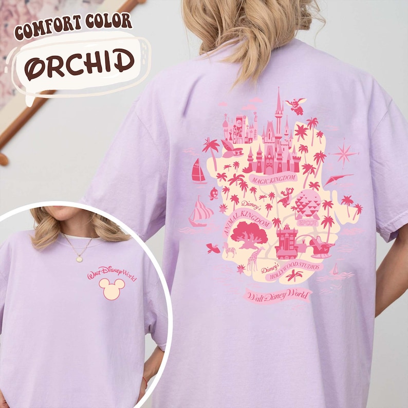 May include: Orchid-colored t-shirt featuring a Disney World map design on the back and a Mickey Mouse logo on the front. The back design includes illustrations of a castle, palm trees, and the words "Magic Kingdom", "Animal Kingdom", and "Hollywood Studios".