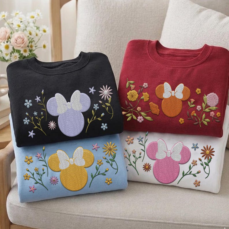 Pu&ograve; includere: Quattro felpe girocollo in nero, rosso, azzurro e bianco. Ognuna presenta una silhouette ricamata di una testa di topo con un fiocco, circondata da vari steli floreali colorati e piccoli fiori cuciti sulla parte anteriore del petto.